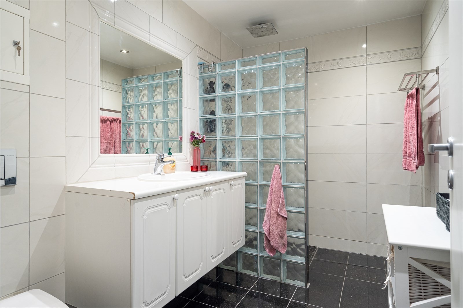 Badet i førsteetasje er fra 2011. Badet er flislagt, har stor dusjnisje og speilet er stillig integrert i veggen. Galleribilde