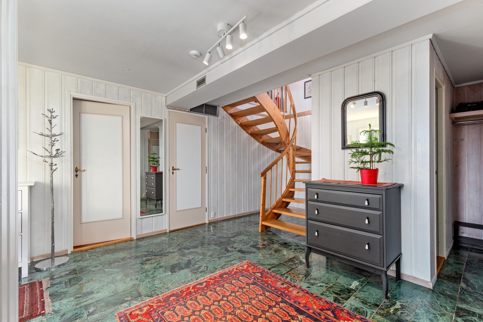 Romslig gang med flislagt gulv i grønn marmor som gir et elegant preg. Galleribilde