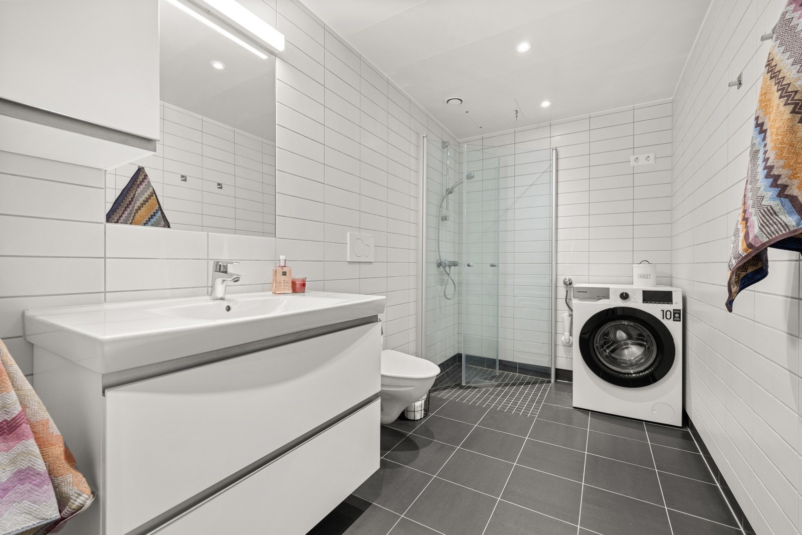 Delikat, flislagt bad med varme i gulvet og opplegg for vaskemaskin. Galleribilde