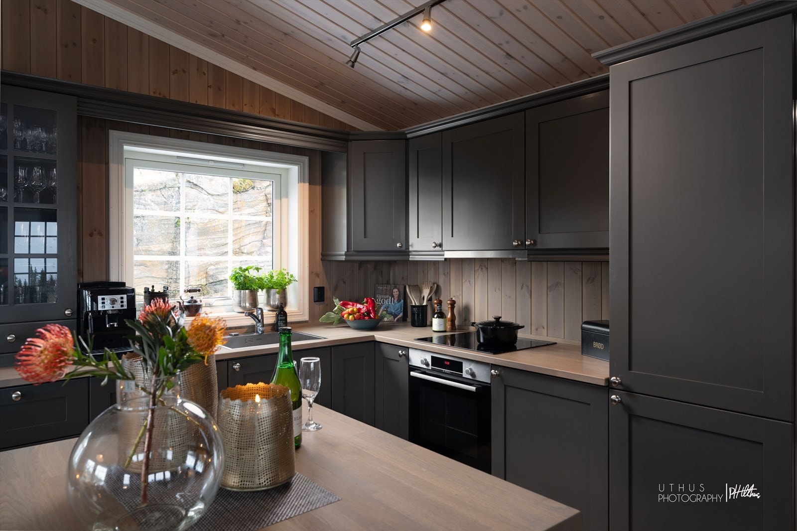 Kjøkkenet har gråmalte, profilerte fronter og benkeplate i heltre med nedfelt vaskekum og platetopp. Innredningen byr på god skapplass med både overskap, benkeskap og kjøkkenøy. Galleribilde