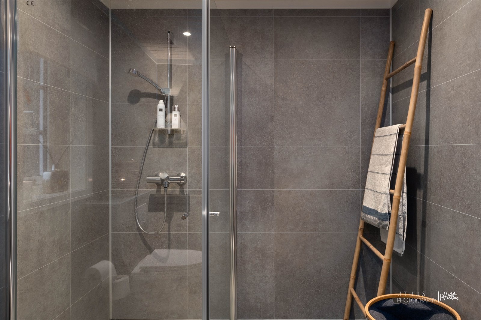 Dusjen er plassert i hjørnet og har mosaikkfliser og håndholdt dusjarmatur. Galleribilde