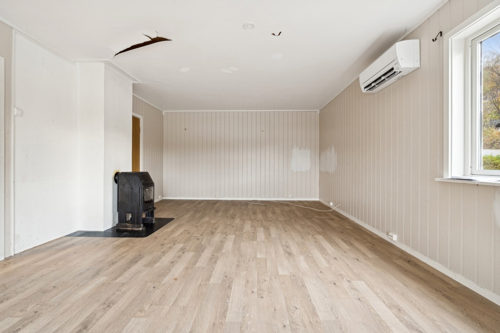 Vedovn bidrar med jevn varme i stuen, mens varmepumpe er montert for effektiv oppvarming. Galleribilde