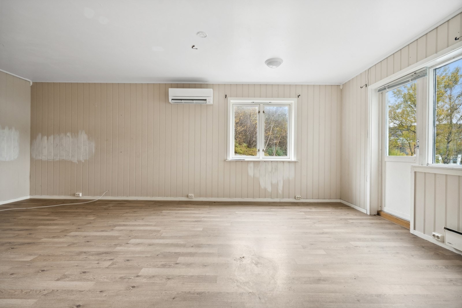 Store vindusflater gir godt med naturlig lys og utsikt mot grøntområdet utenfor. Galleribilde