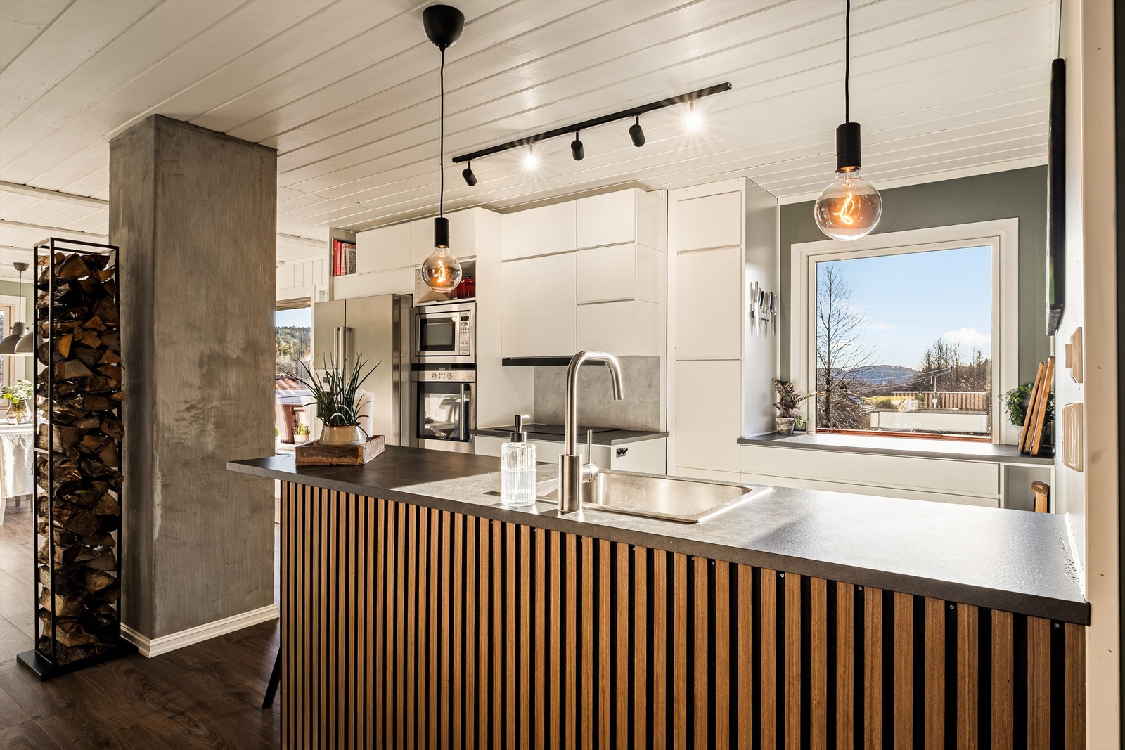 Kjøkkenet ligger i delvis åpen løsning mot stuen og har godt med både skap og benkplass Galleribilde