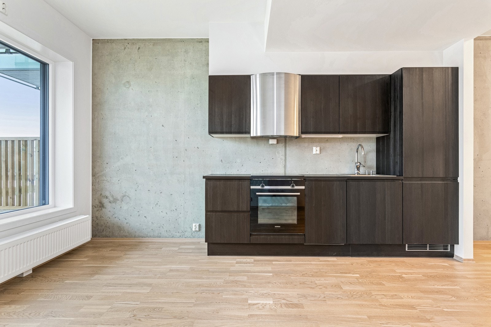 Leiligheten har åpen stue-/kjøkkenløsning som danner et sosialt allrom. Galleribilde