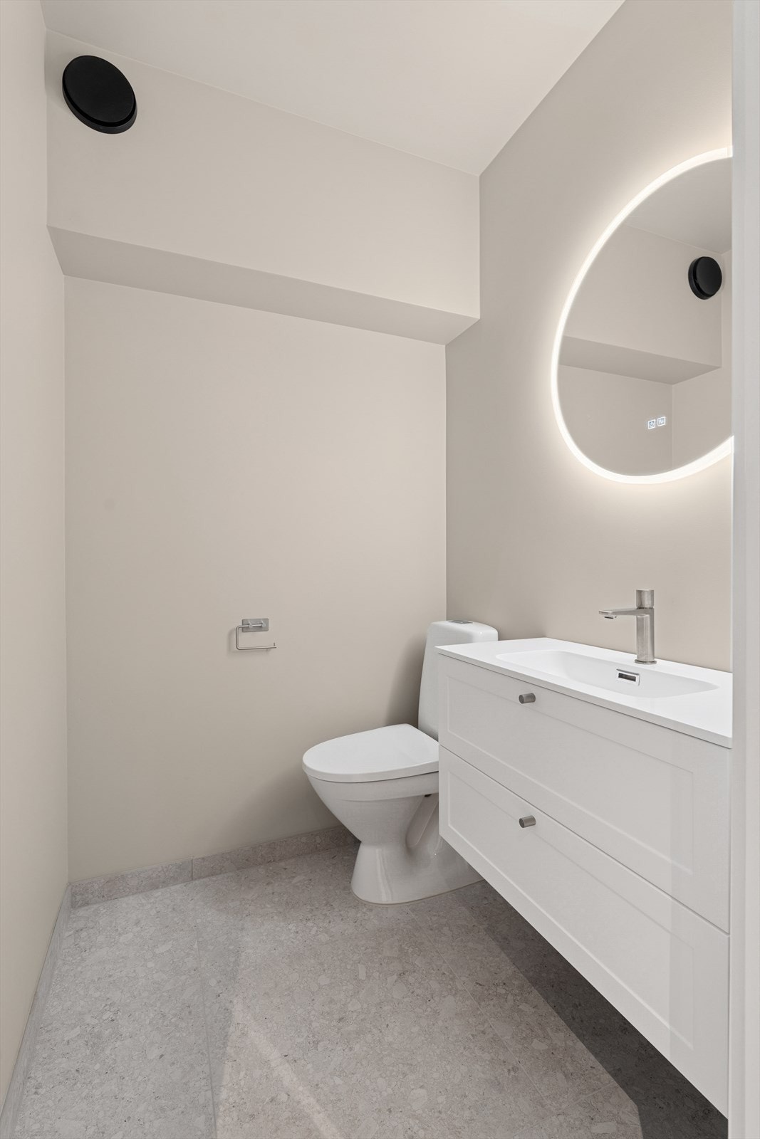 Vegg i vegg med badet og med praktisk tilkomst fra entreen, er det ekstra gjestetoalett med toalett og servant. Galleribilde