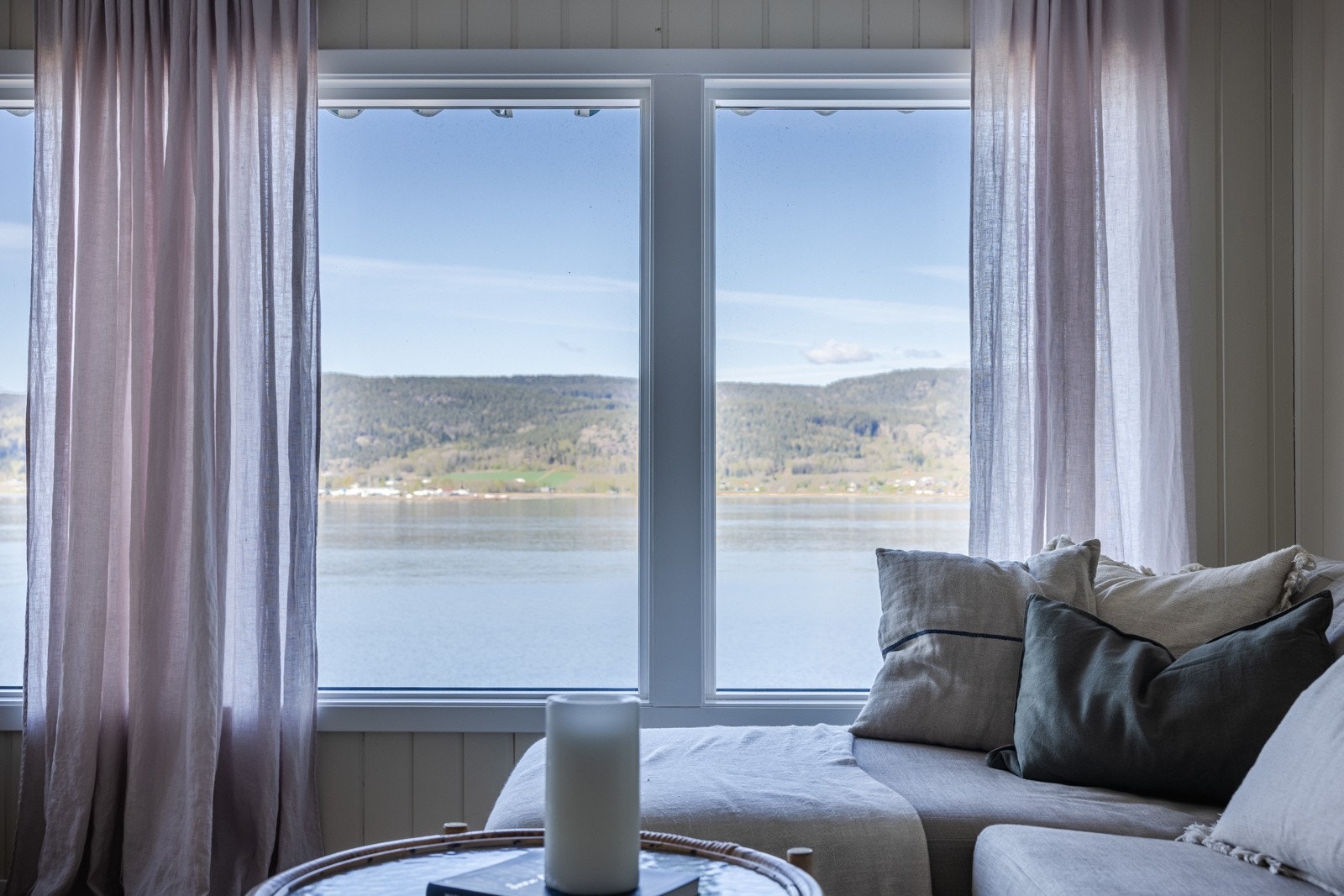 Rommet får rikelig med dagslys og nydelig fjordutsikt fra en vindusrekke mot vest i stuesonen. Galleribilde