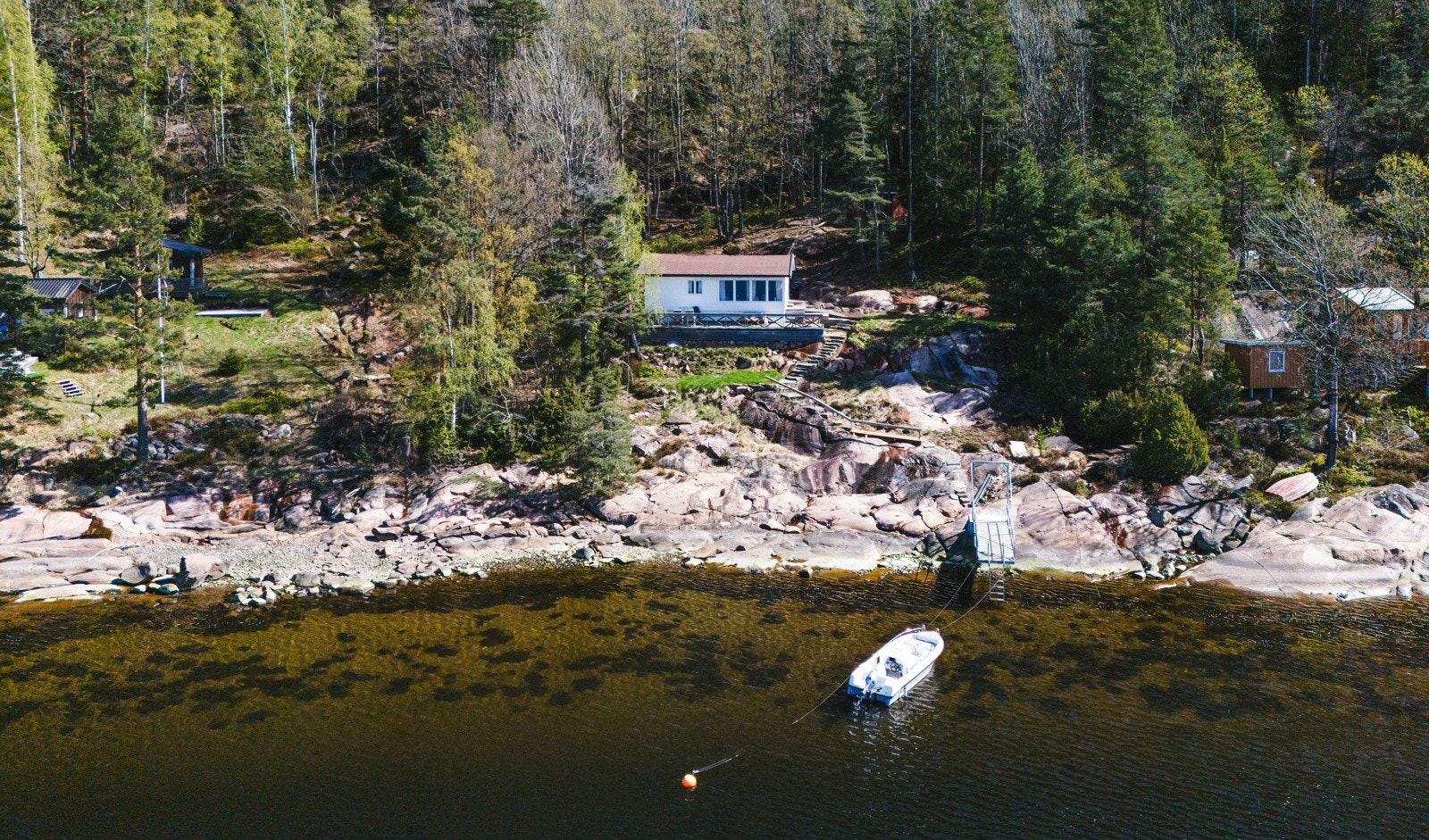 Hytta ligger høyt på tomten og har vestvendt terrasse på ca. 35 kvm, samt en skjermet markterrasse med utedusj, benk og vask med sommervann. Galleribilde