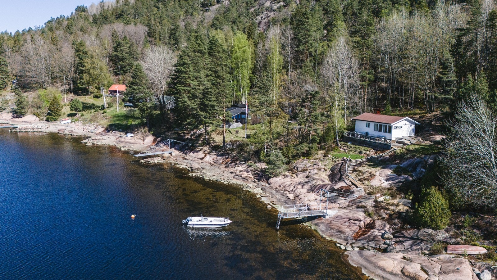 Velkommen til en stor og usjenert fritidseiendom med velholdt hytte, strandlinje og brygge med båtplass. Galleribilde