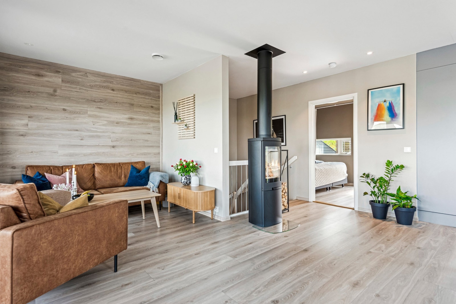 Gjennomgående laminatgulv og en fondvegg med trestruktur binder rommene sammen. Galleribilde