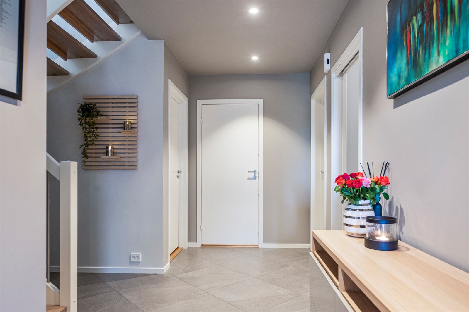 Fra entreen leder en malt tretrapp med eiketrinn opp til boligens hovedetasje. Galleribilde