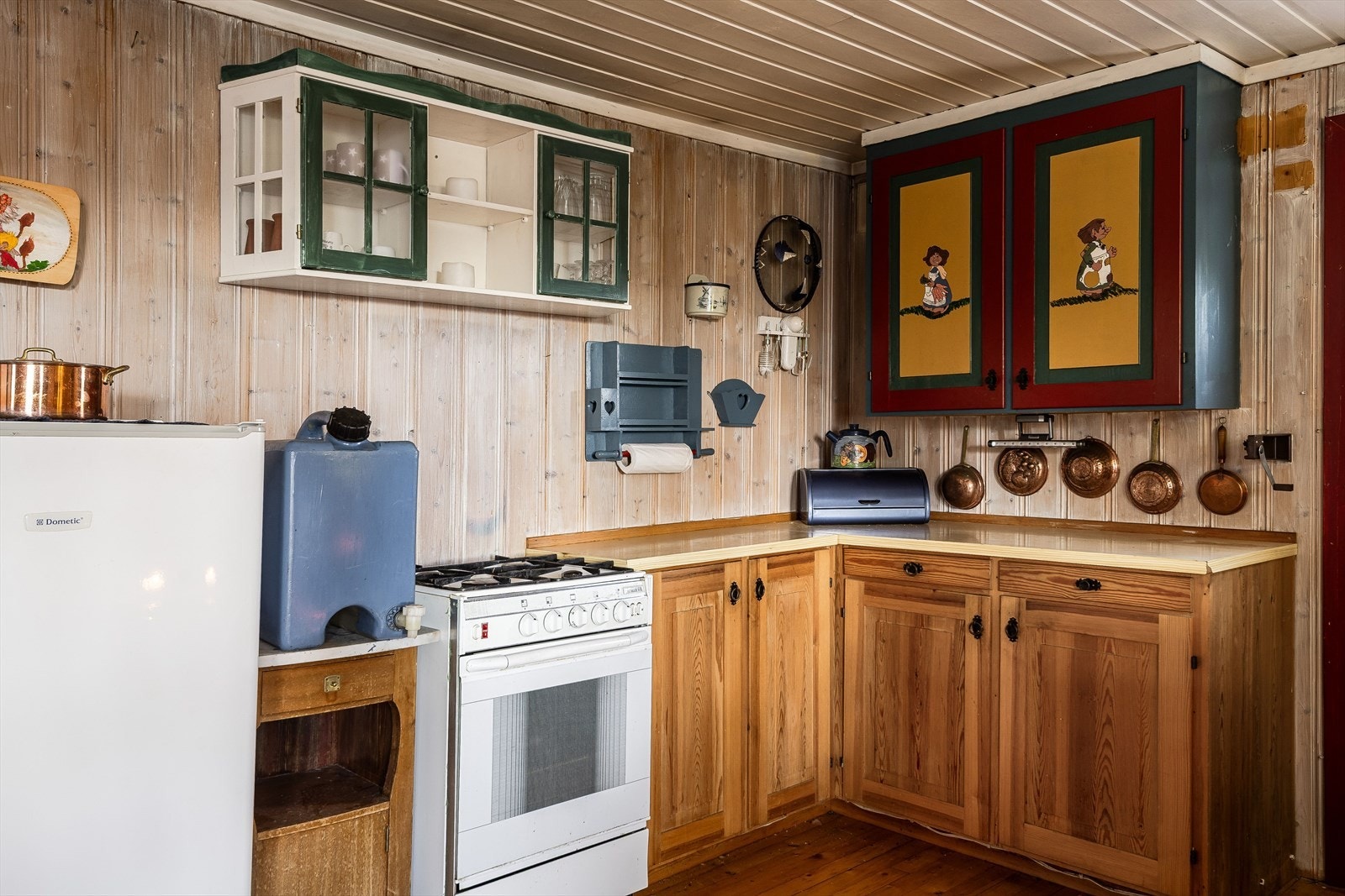 Kjøkkeninnredning med laminert benkeplate, over- og underskap, speilfronter og del med glassdører. Vann hentes fra en av hyttefeltets vannposter. Galleribilde