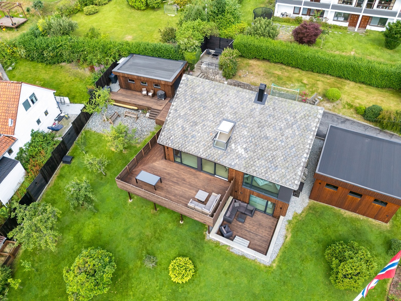 Pent opparbeidet tomt med terrasse og plen. Galleribilde