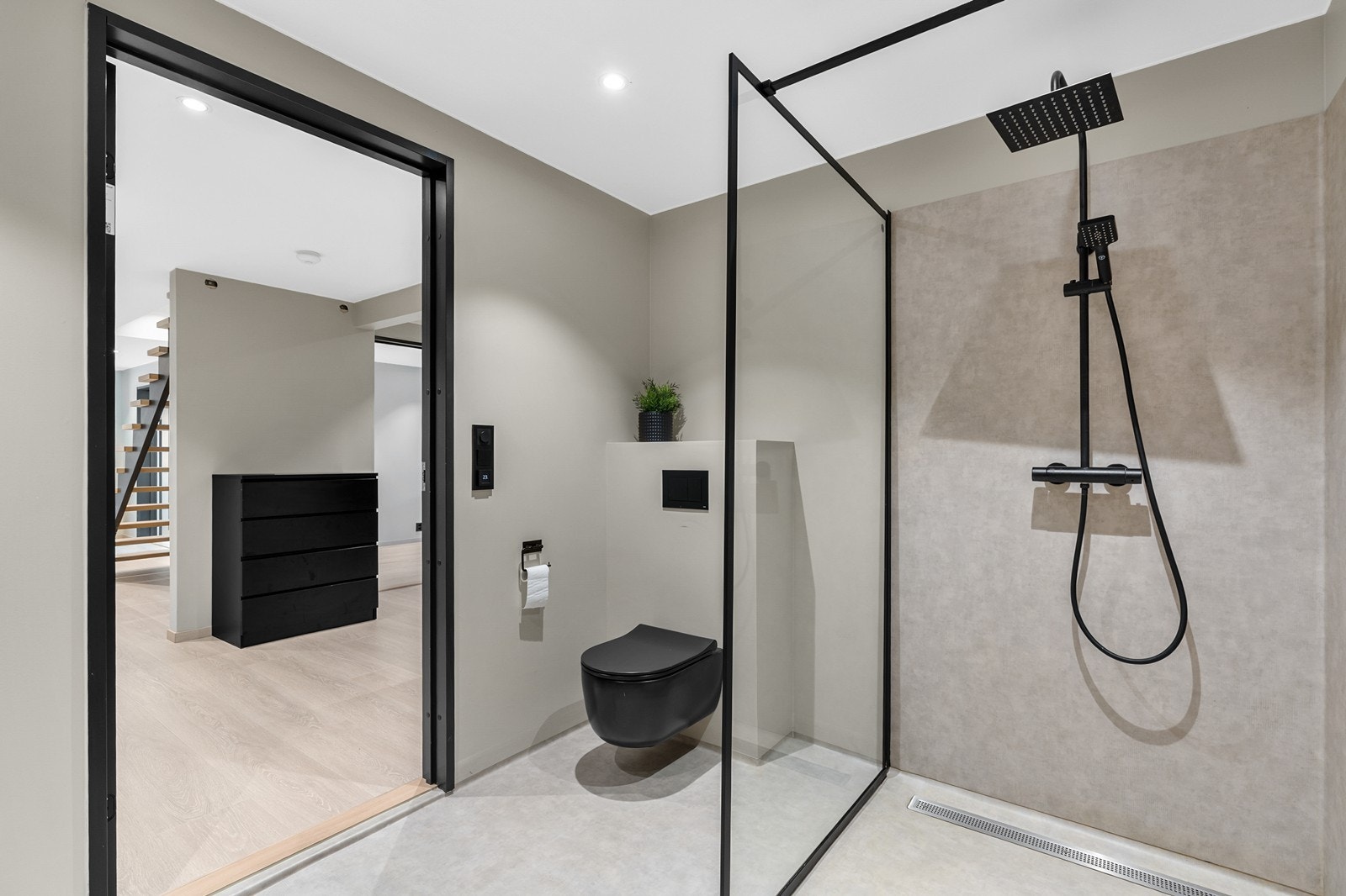 Rommet er innredet med baderomsinnredning med servant, veggmontert toalett og dusjvegger/hjørne. Galleribilde