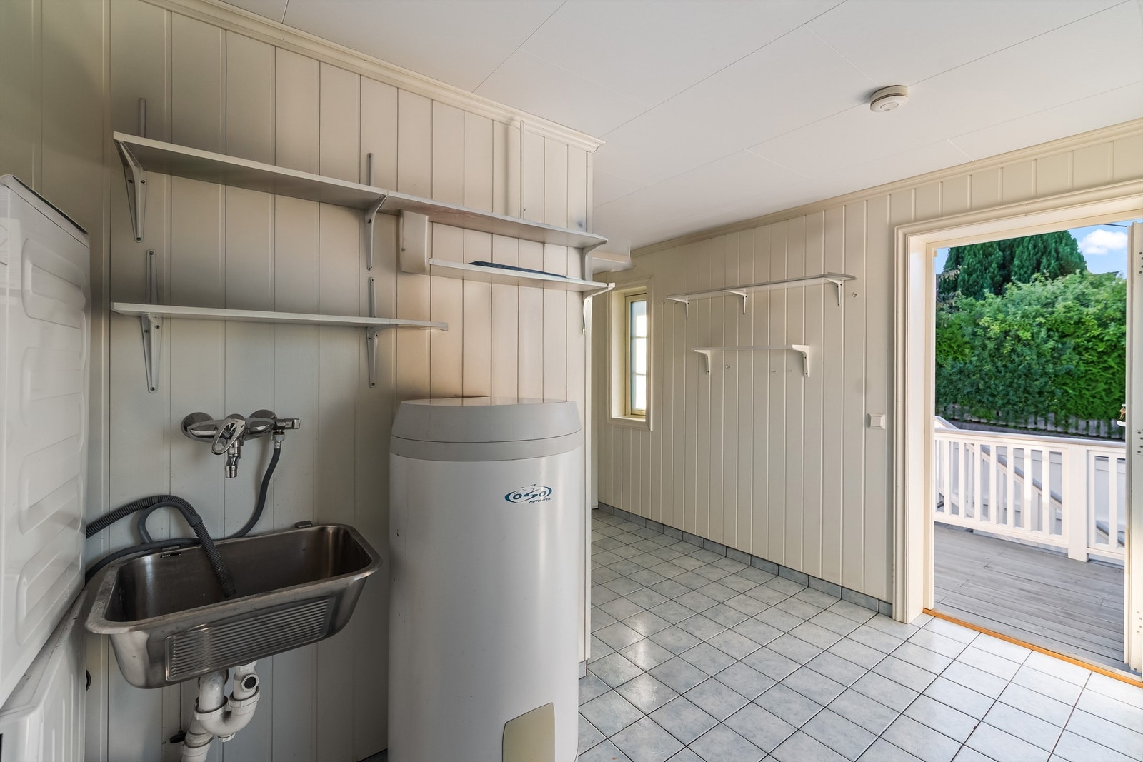 I 1. etasje er det også innredet et meget romslig vaskerom. Her er gulvflatene belagt med fliser, og veggene har malte panelplater. Vaskerommet har egen inngang - perfekt etter luftetur med familiens hund, eller når de minste kommer sølete hjem. Galleribilde