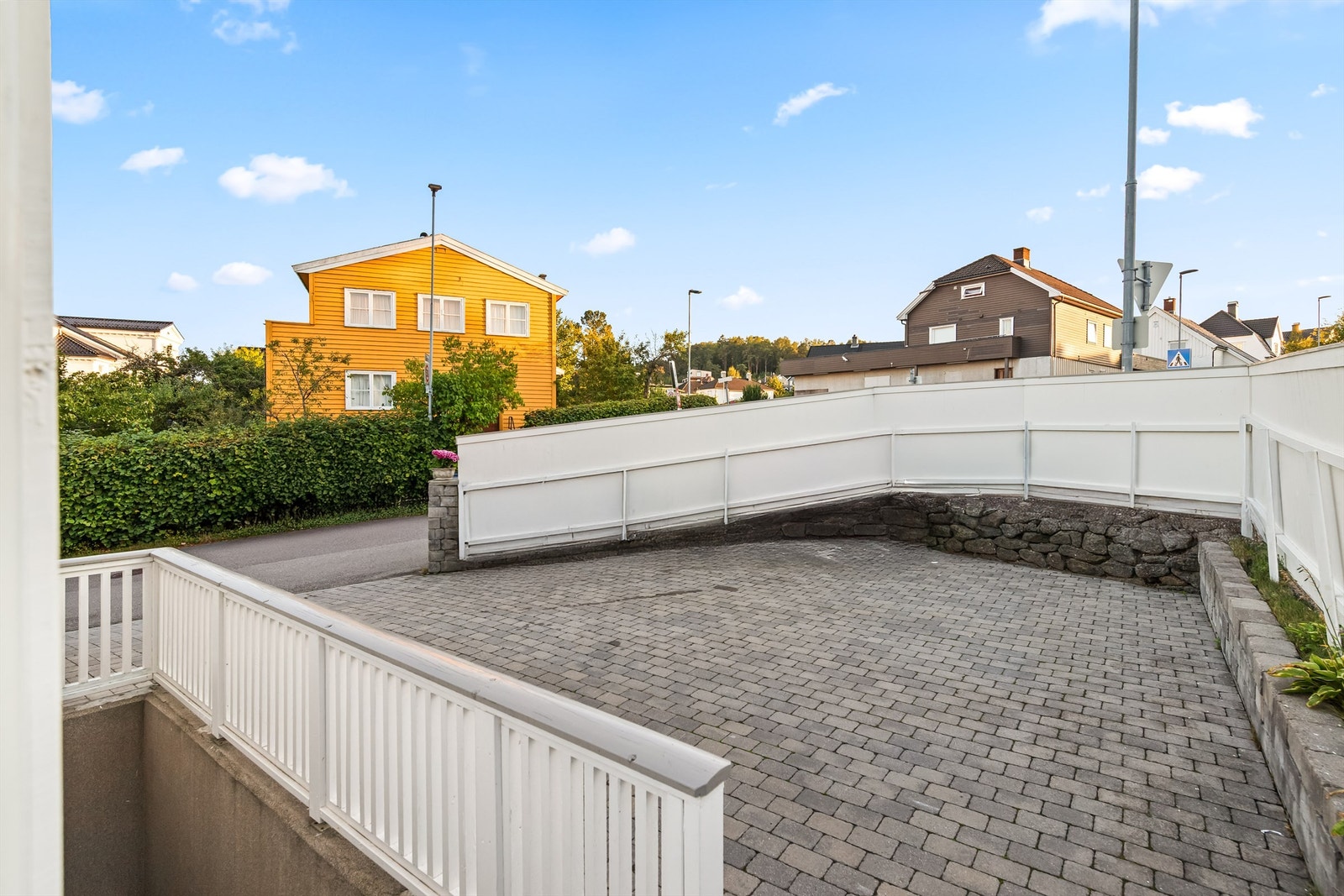 Gårdsplassen er pent belagt med belegningsstein og har rikelig med parkeringsplass. Det er også opparbeidet en mindre biloppstillingsplass syd øst på tomten. Galleribilde