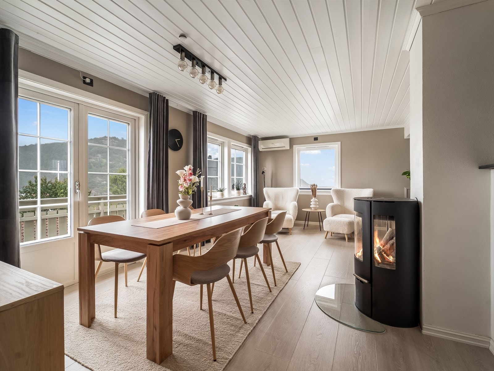 Lys og innbydende stue med plass til spisestuemøblement. Nyere vedovn i stua gir varme og stemning til rommet. Varmepumpe på vegg. Galleribilde