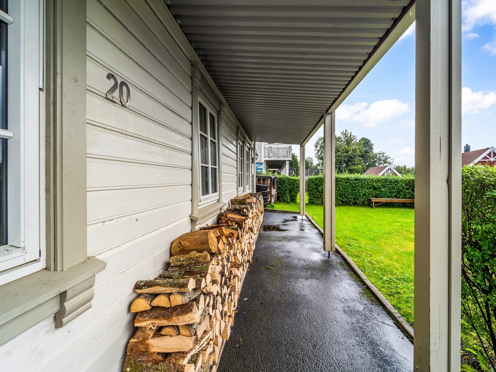Uteområde i front av boligen med plenområde omgitt av hekk. Galleribilde