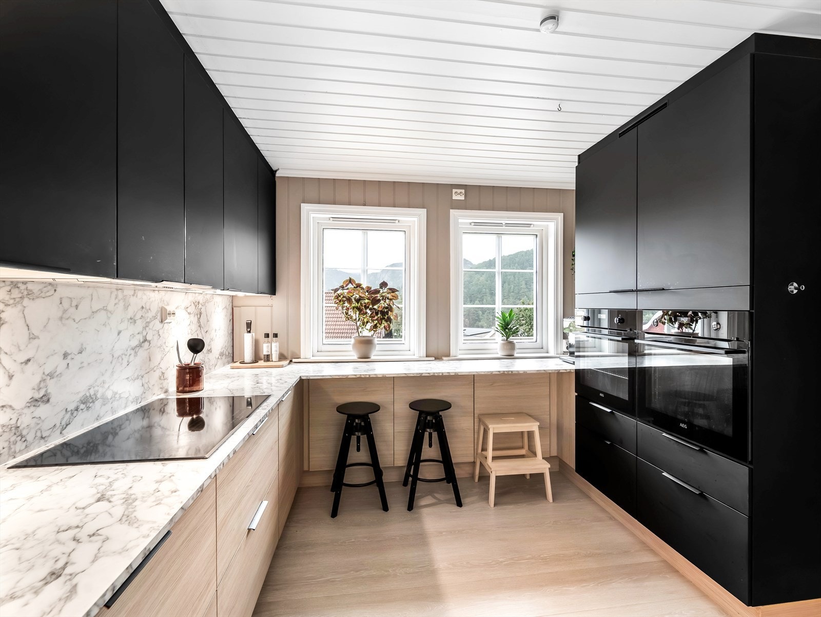 Flott kjøkken med mye skap- og benkeplass. Barstolløsning under kjøkkenbenk. Galleribilde