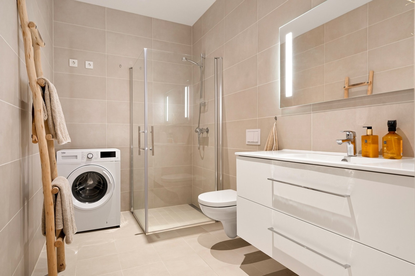 Delikat, moderne bad med beige fliser på gulv og vegger Galleribilde