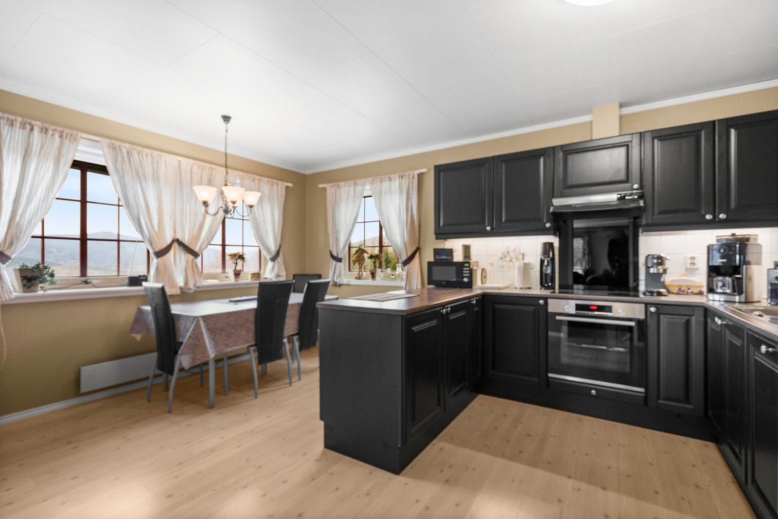 Kjøkken med stor spiseplass. Her er det godt med arbeids og skapplass. Galleribilde