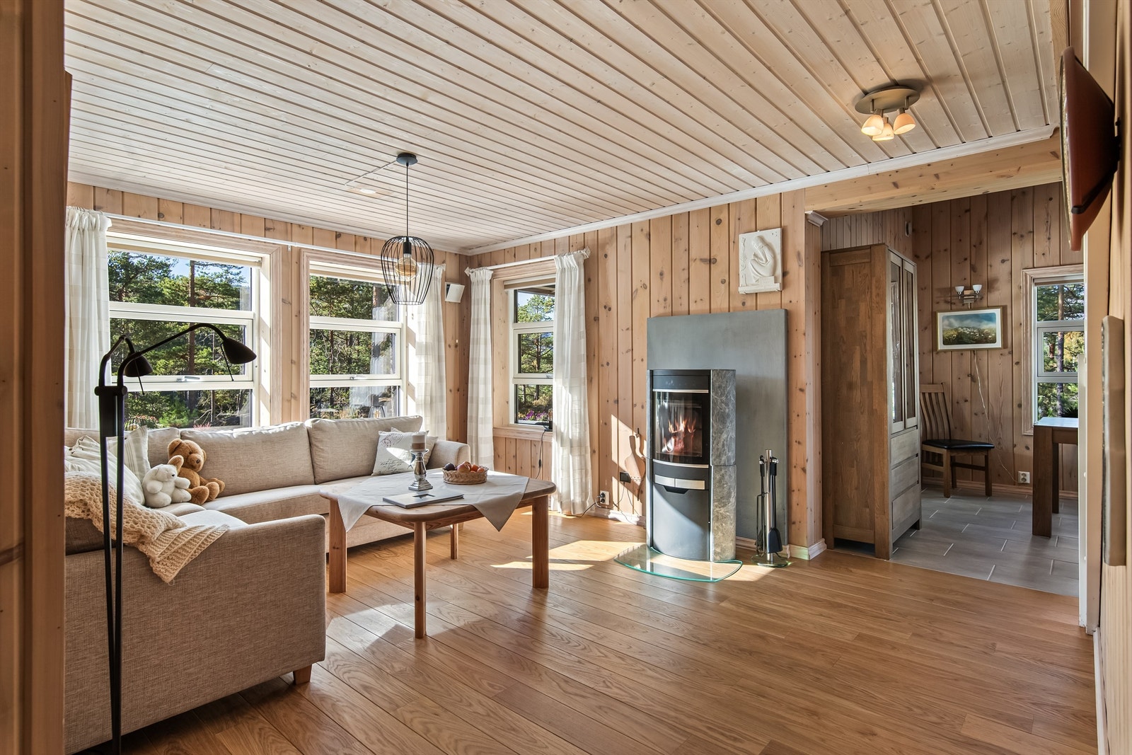 Stuen har store vindusflater mot usjenerte naturområder Galleribilde