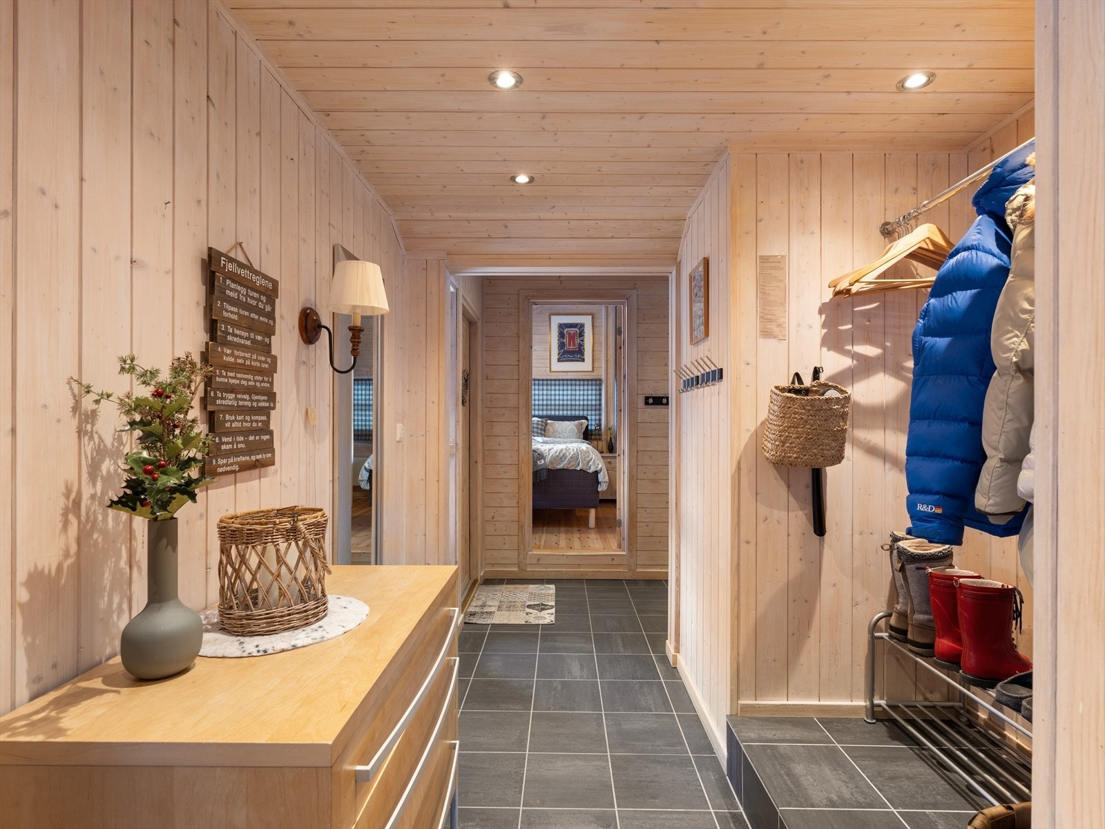 Stor og romslig gang med fliser på gulv og varmekabler under. Lysnet panel med spotter i tak. Galleribilde