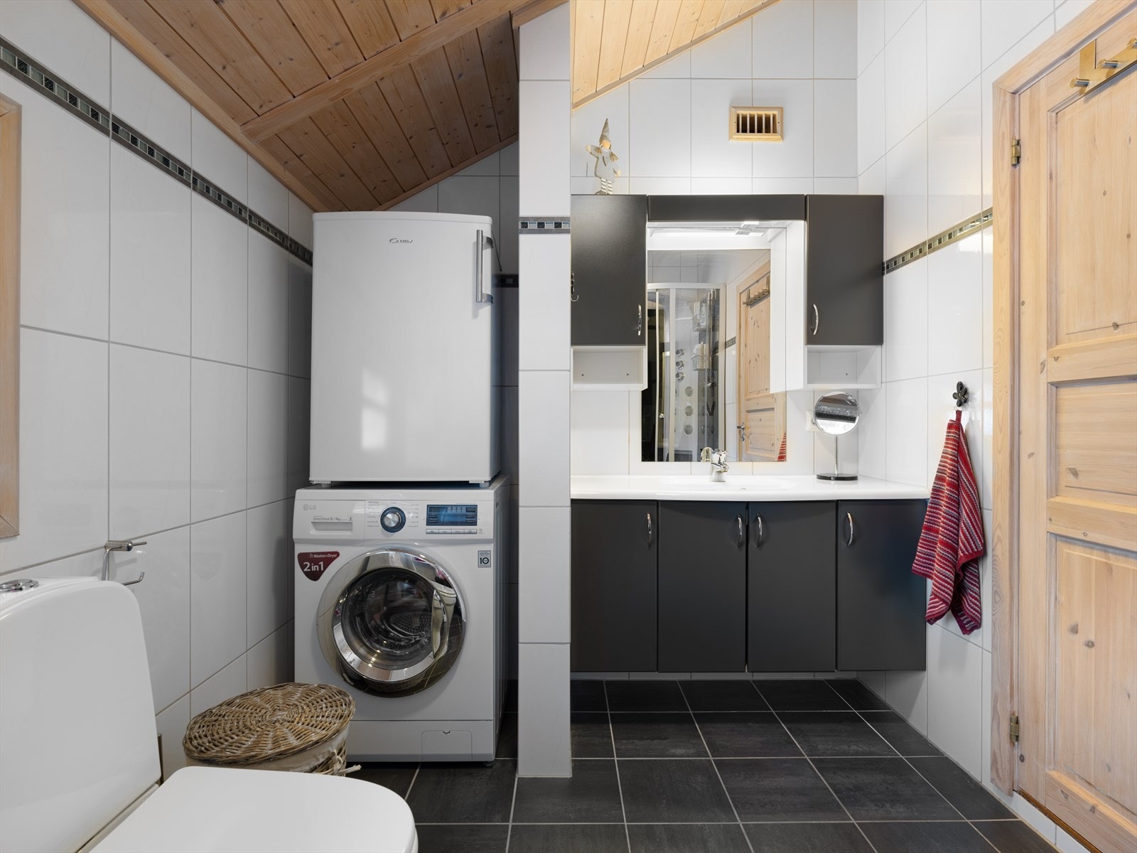 Bad/vaskerom med dusjkabinett, wc og vask i seksjon. Nisje med plass til vaskemaskin. Galleribilde