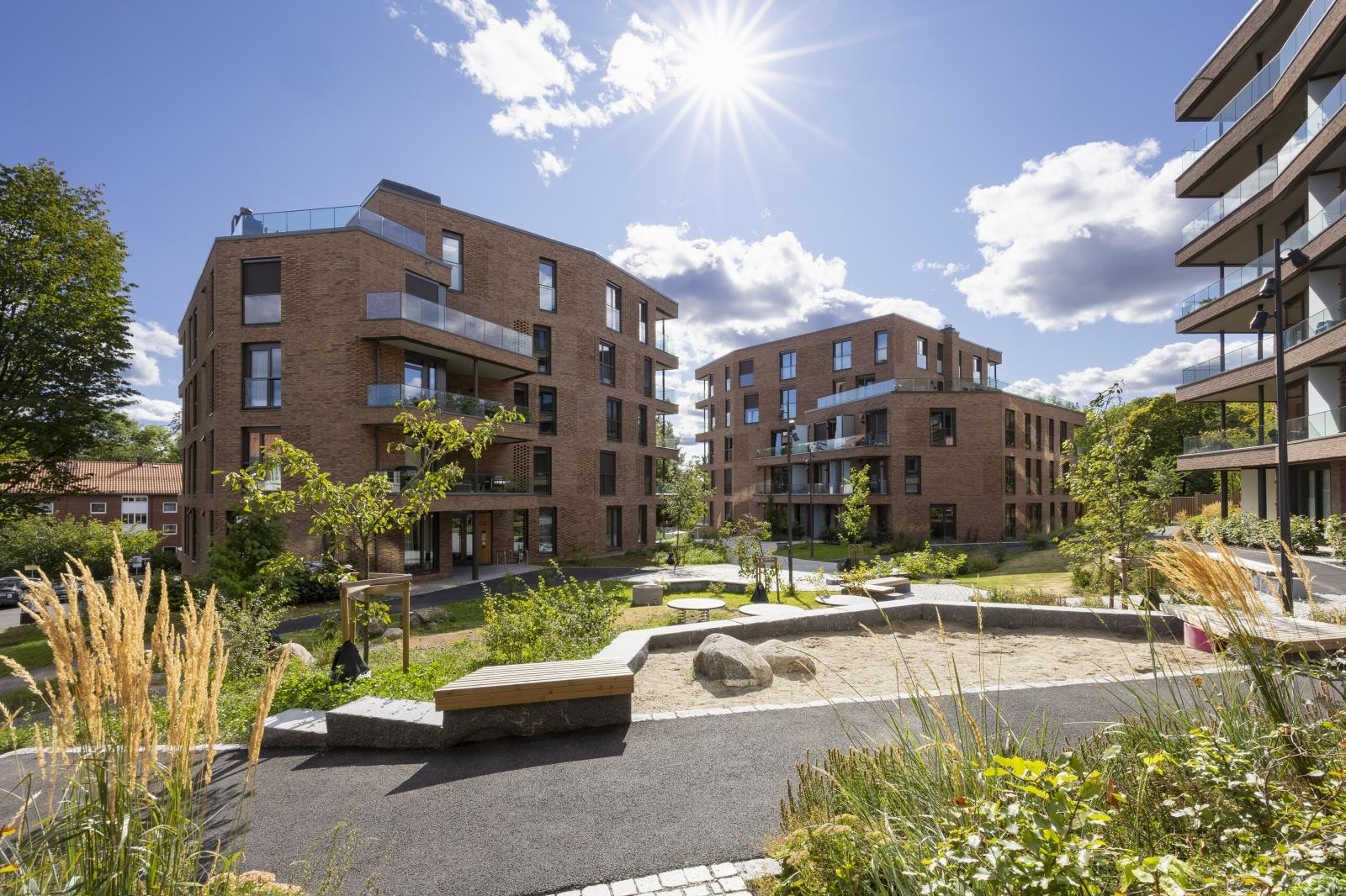 Tunet er opparbeidet med flere ulike sittebenker, lekeapparater og pen beplantning. Galleribilde