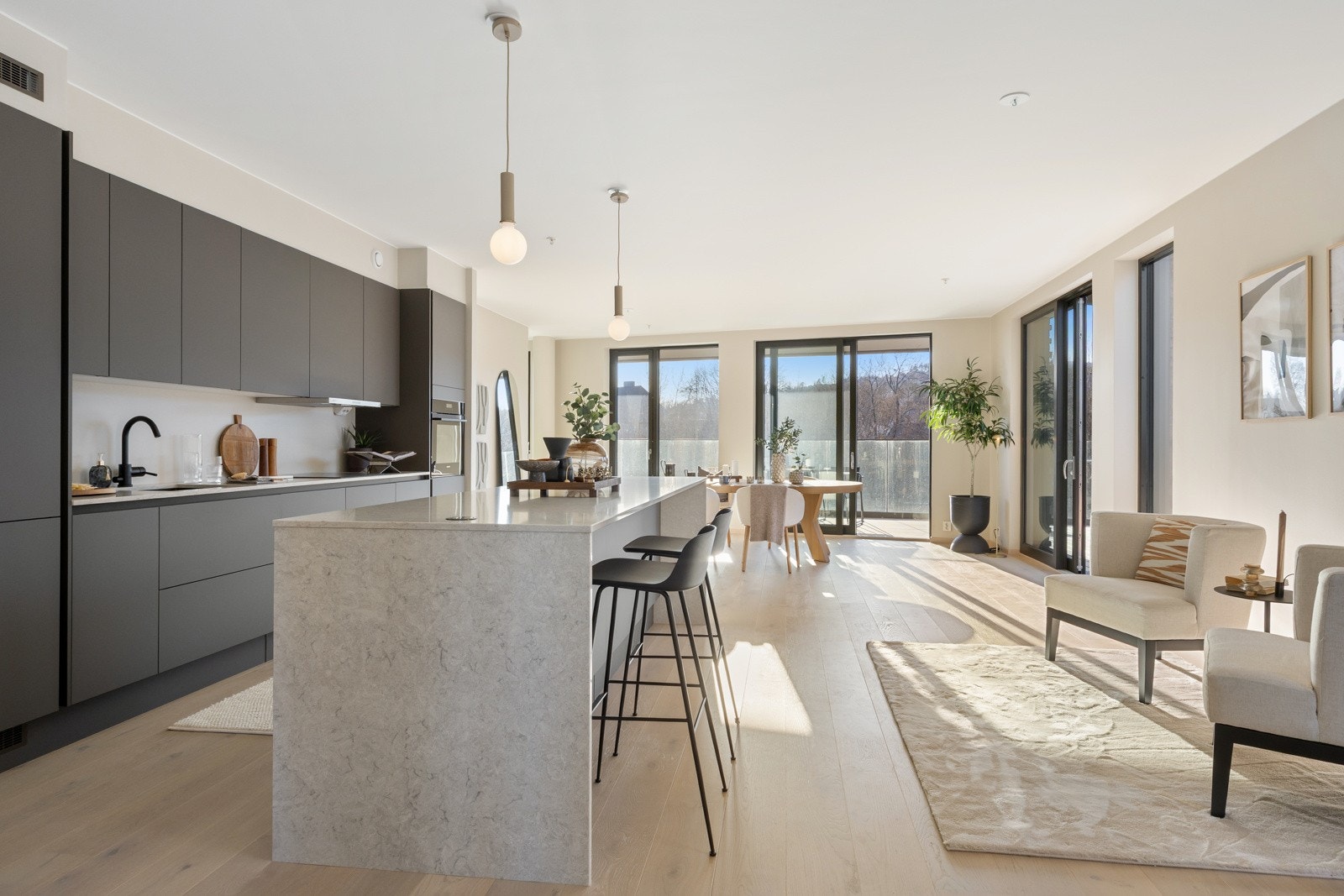 Et lekkert kjøkken fra HTH er utstyrt med en stor og flott øy i overgangen til deler av stuen. Galleribilde