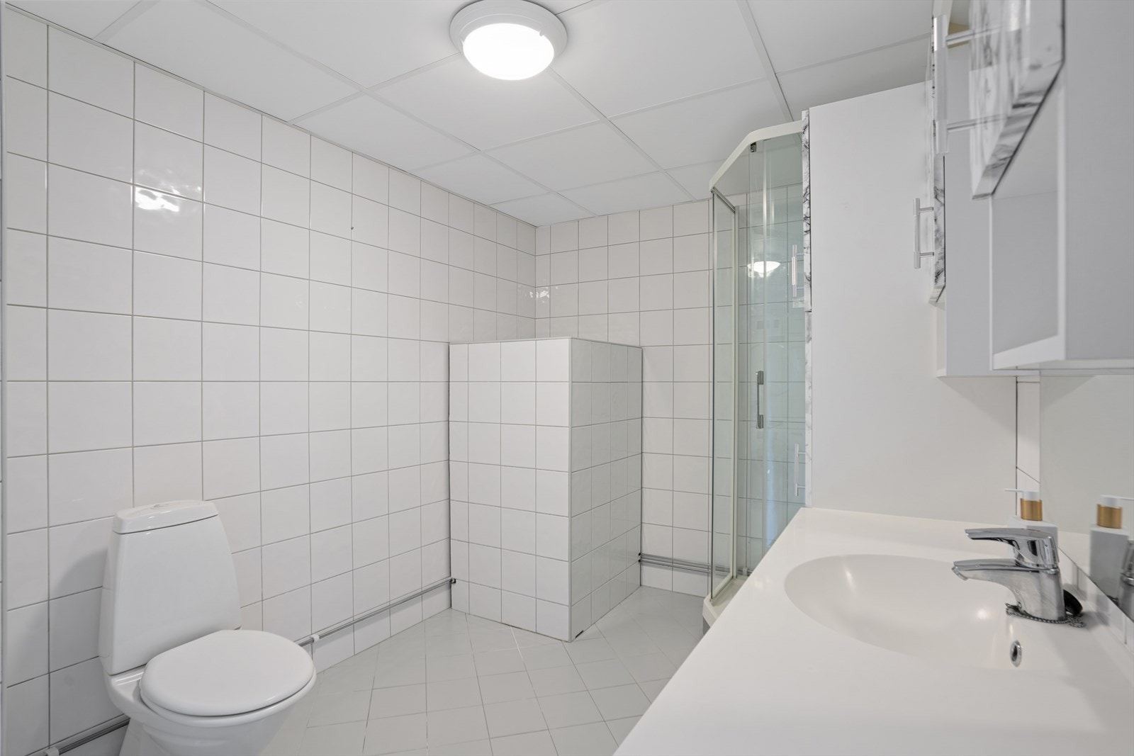 Stort baderom fra 2009 i regi av borettslaget med fliser på gulv og vegger, samt gulvvarme. Galleribilde