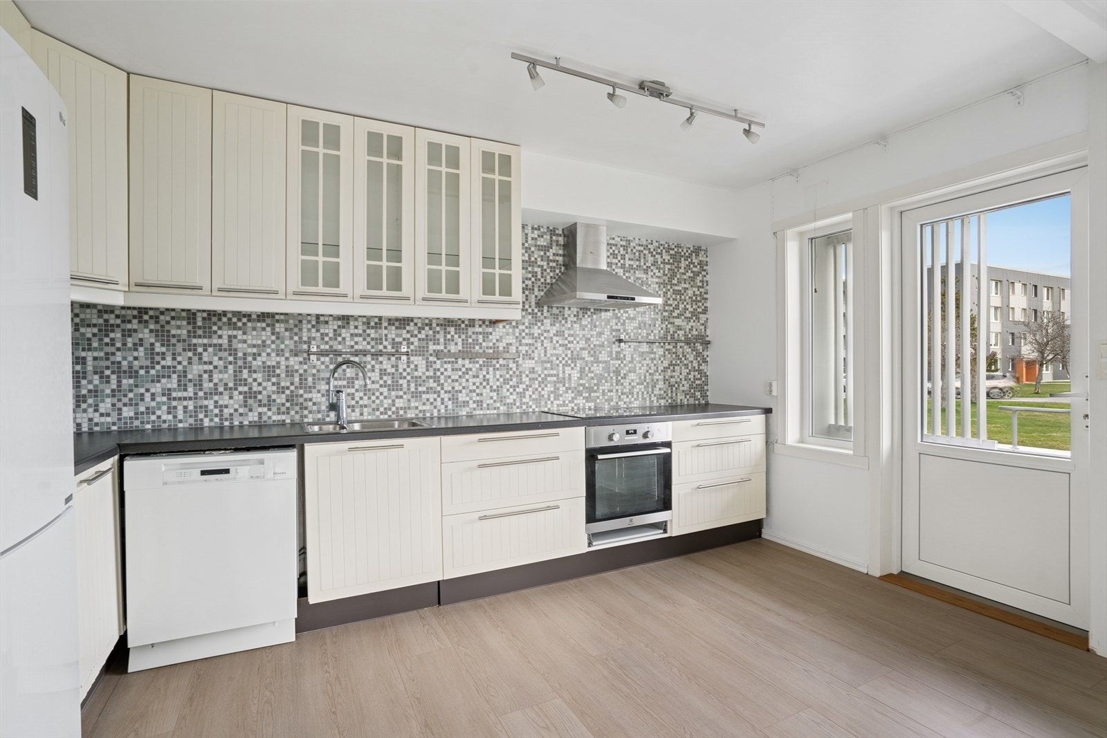 Videre er det fliser på vegg over benkeplate i laminat. Galleribilde