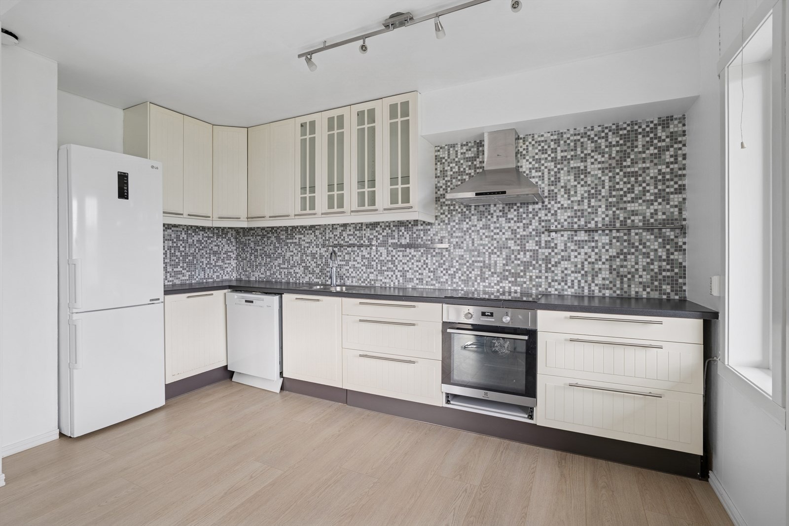 Kjøkkeninnredning med profilerte fronter og noen overskap i glass. Galleribilde