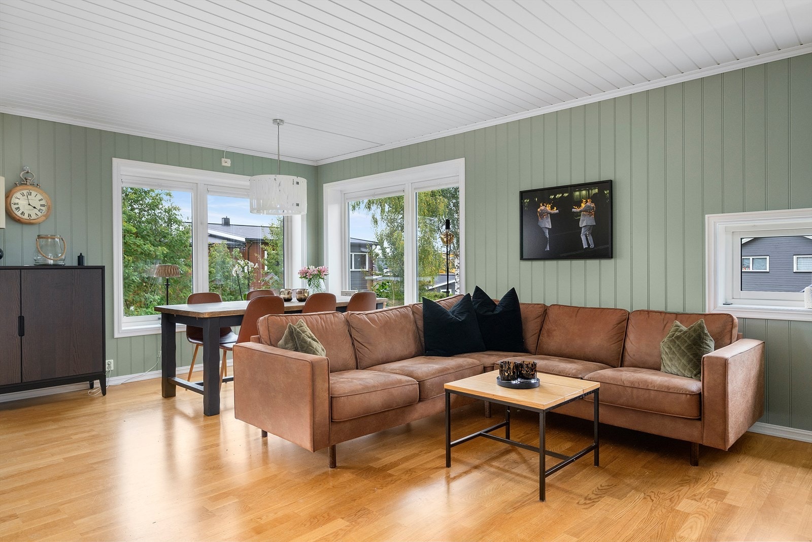 Stuen ligger i en åpen løsning med kjøkkenet og har god tilførsel av naturlig lys Galleribilde