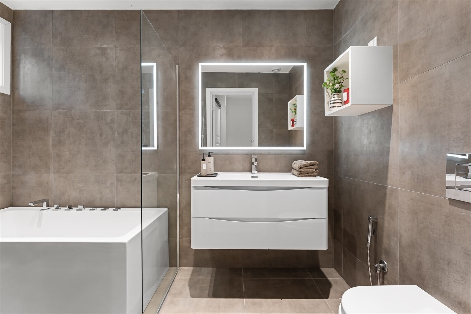 Vegghengt innredning med vask og speil med lys. Galleribilde