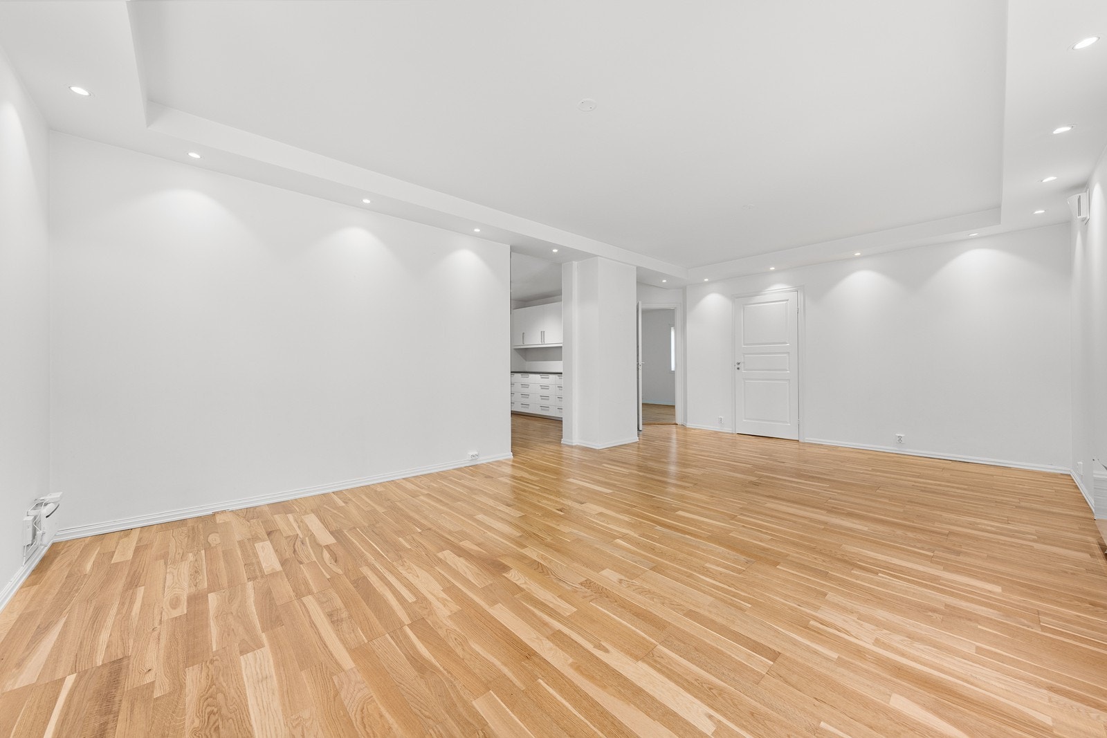 Stuen har hvite slette overflater og parkett på gulv. Galleribilde