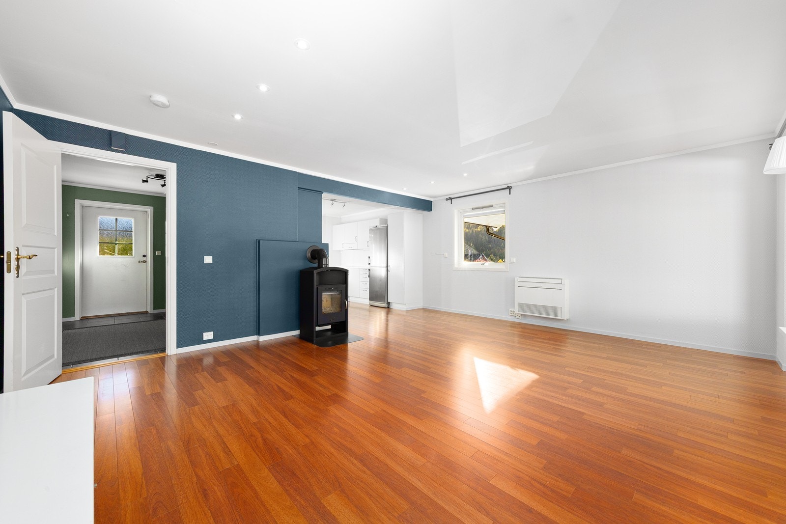 Sentralt plassert i rommet er en lun og koselig vedovn. Galleribilde