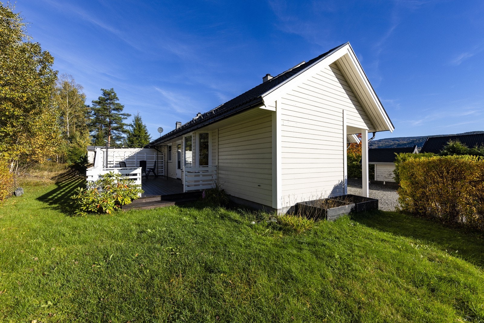 Gruset adkomst og felles parkering på tomannsboligens felles tomt. Galleribilde