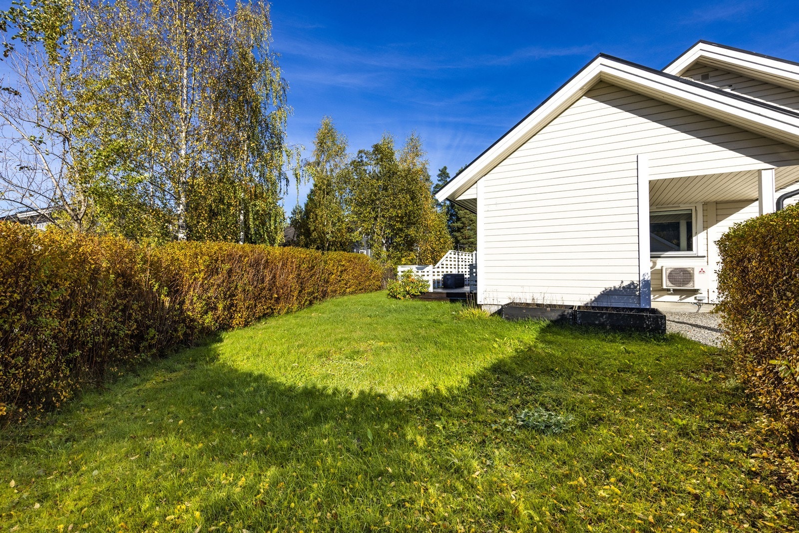 Tomta er opparbeidet med plen og beplantning. Galleribilde