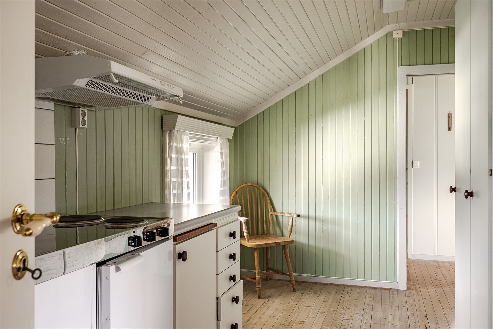 Kjøkkenet har tregulv og panel på veggene malt i en sjarmerende grønnfarge. Galleribilde