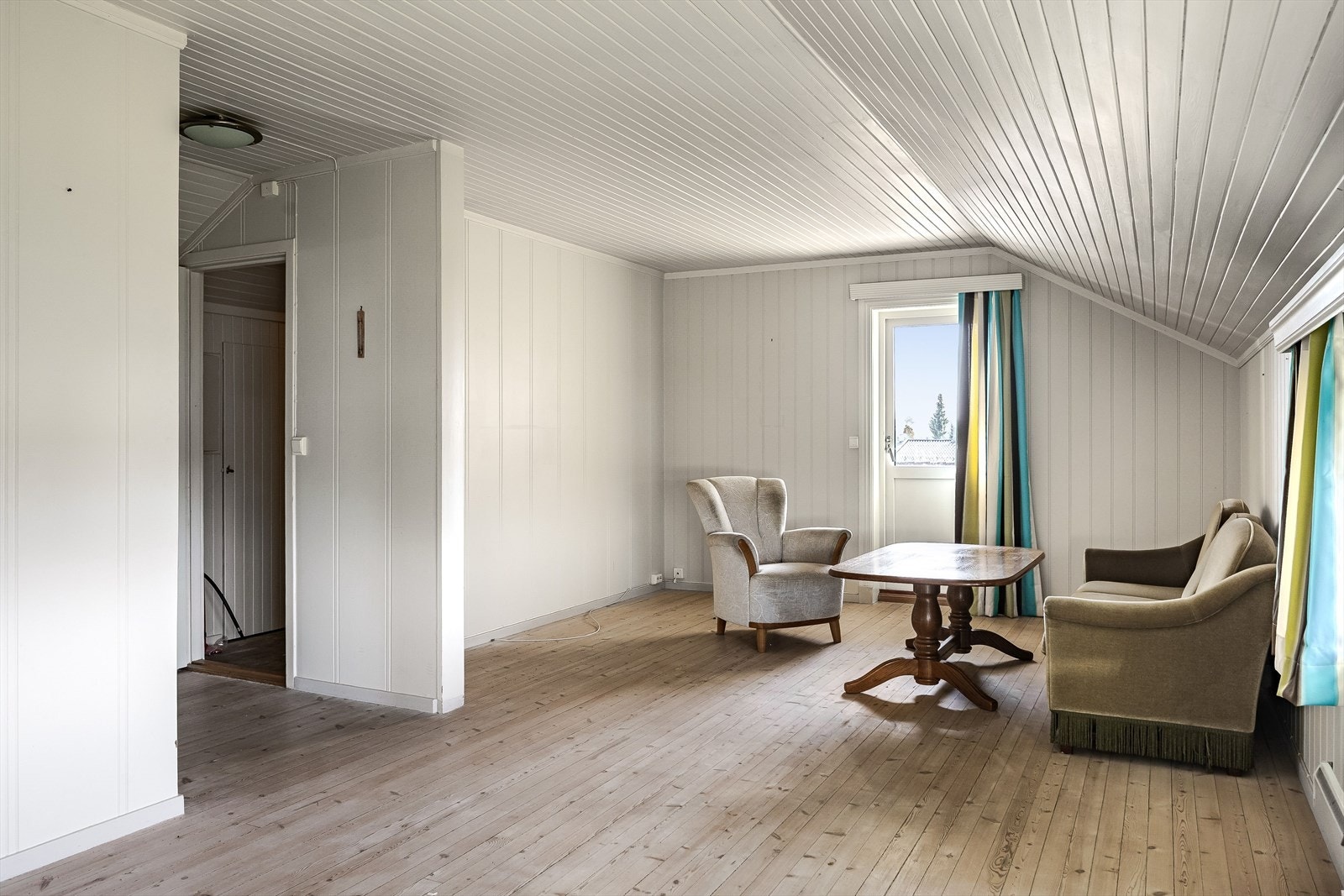 Lys og romslig stue i 2. etasje med tregulv og lysmalte overflater. Galleribilde