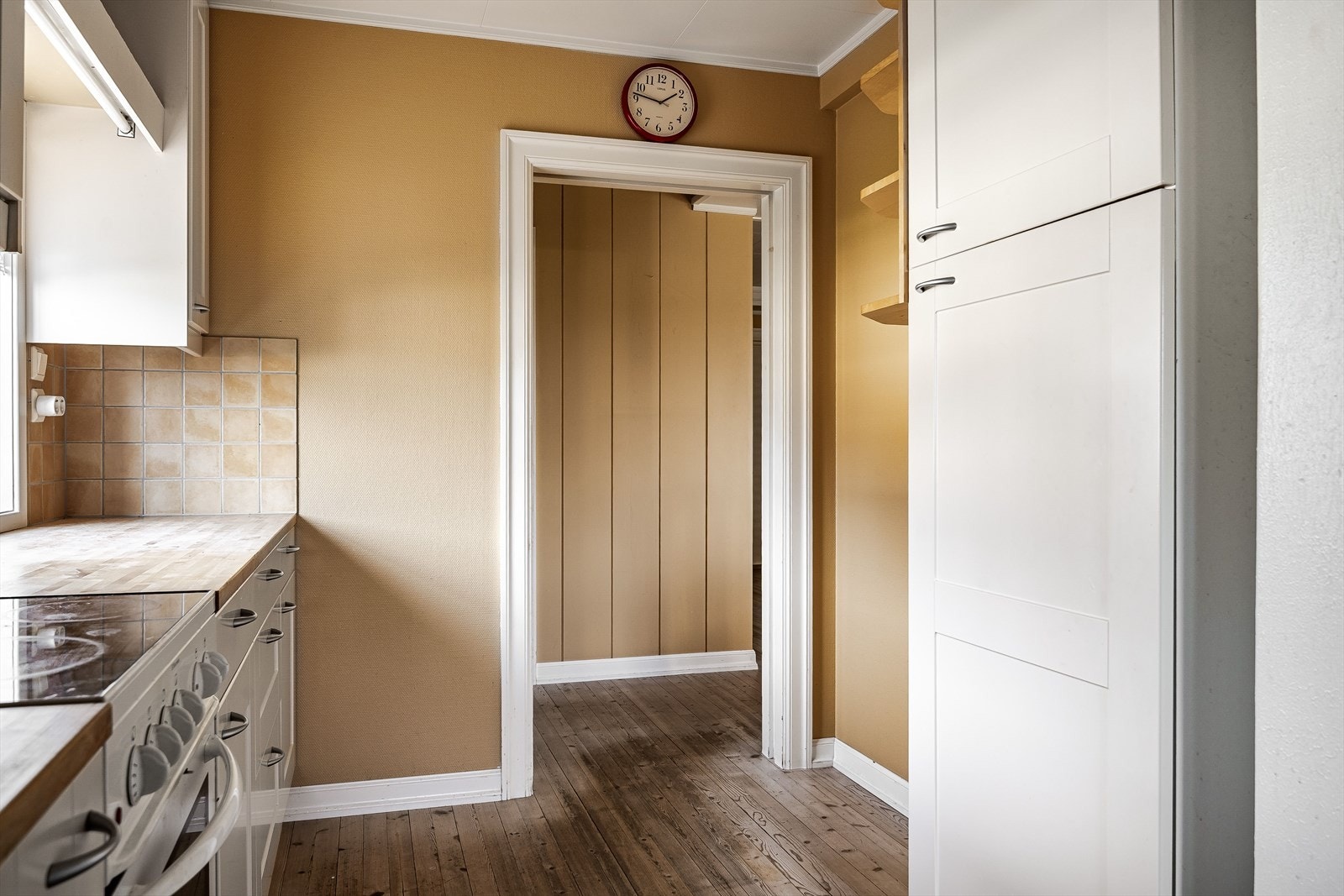 Kjøkkenet har tregulv og malt strietapet på veggene. Galleribilde