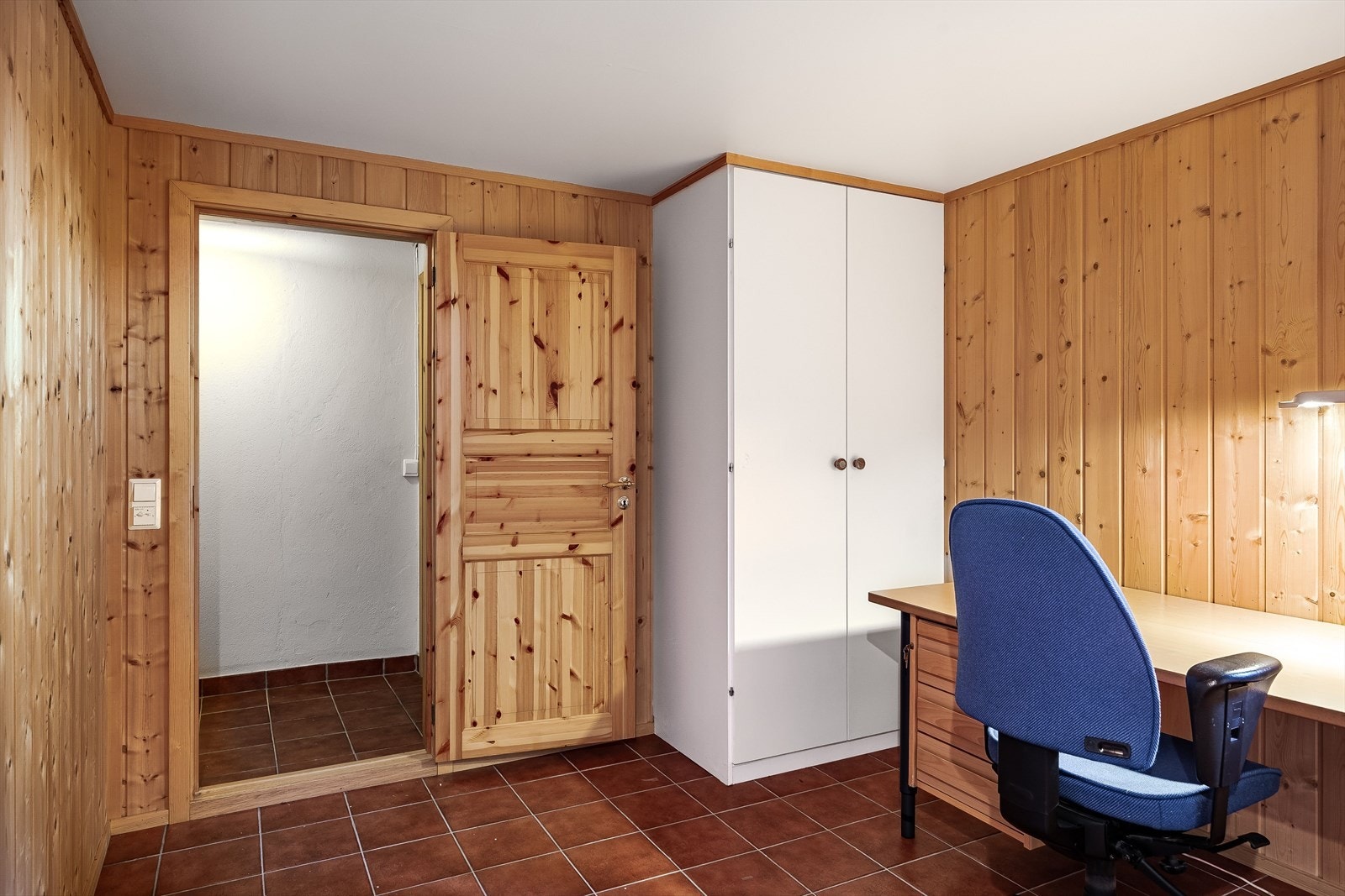 Rommet har flislagt gulv med gulvvarme, trepanel på veggene og oppbevaringsplass i garderobeskap. Galleribilde