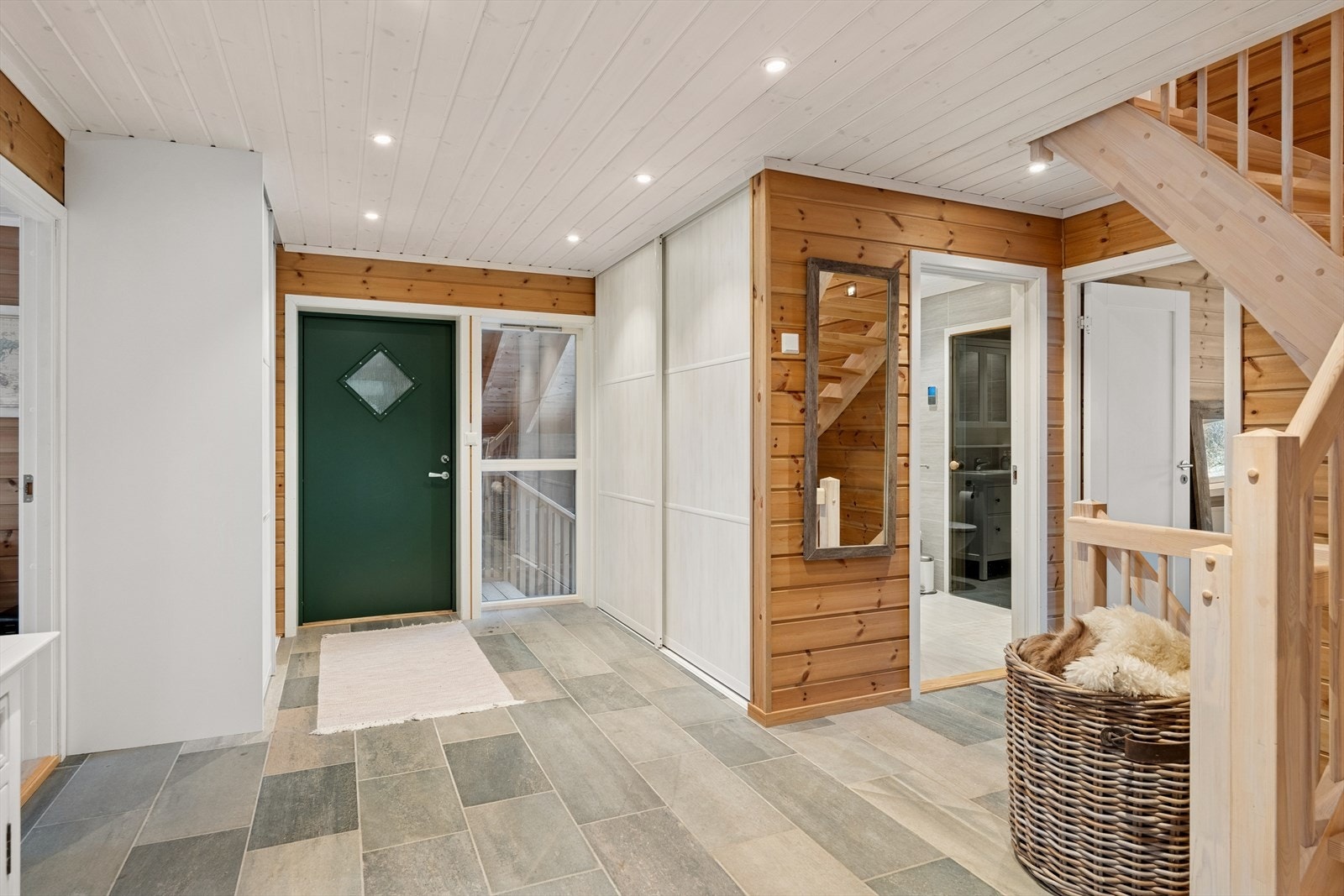 Malt ytterdør med glassfelt gir lysinnslipp og en innbydende inngang til hytta. Galleribilde