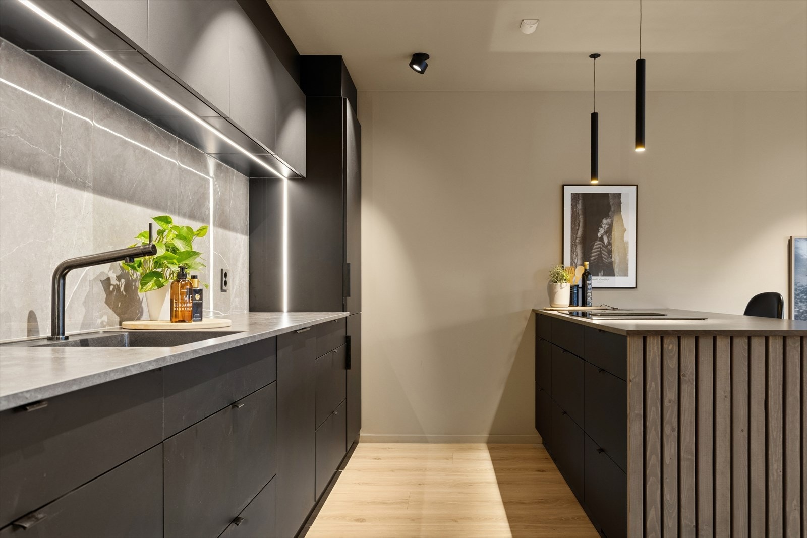 Kjøkkeninnredning med folierte skrog, slette fronter og laminert benkeplate. Flis på vegg over benkeplaten. Galleribilde