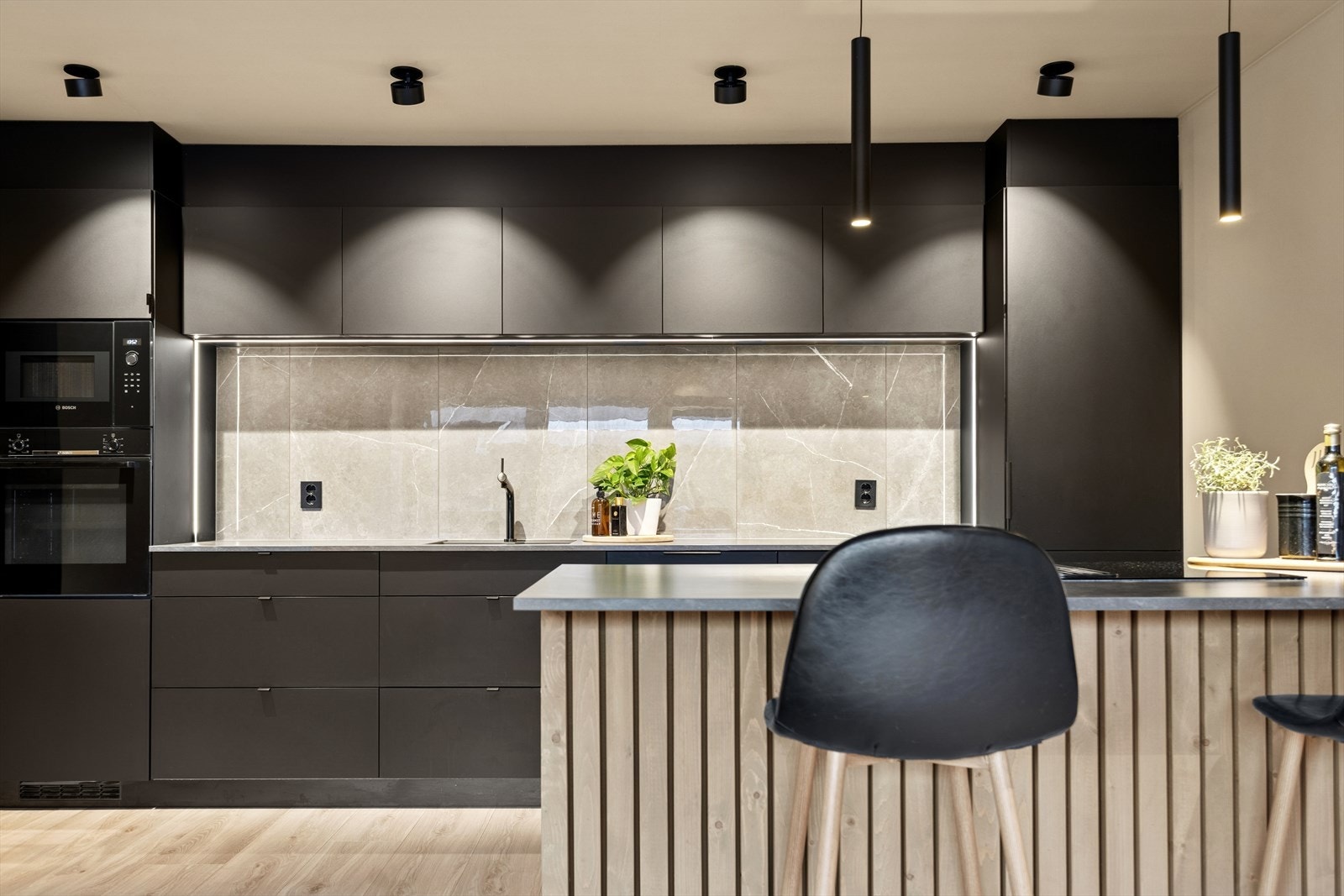 Kjøkkenet har rikelig med skap- og benkeplass samt tidsriktig og stilig belysning. Galleribilde