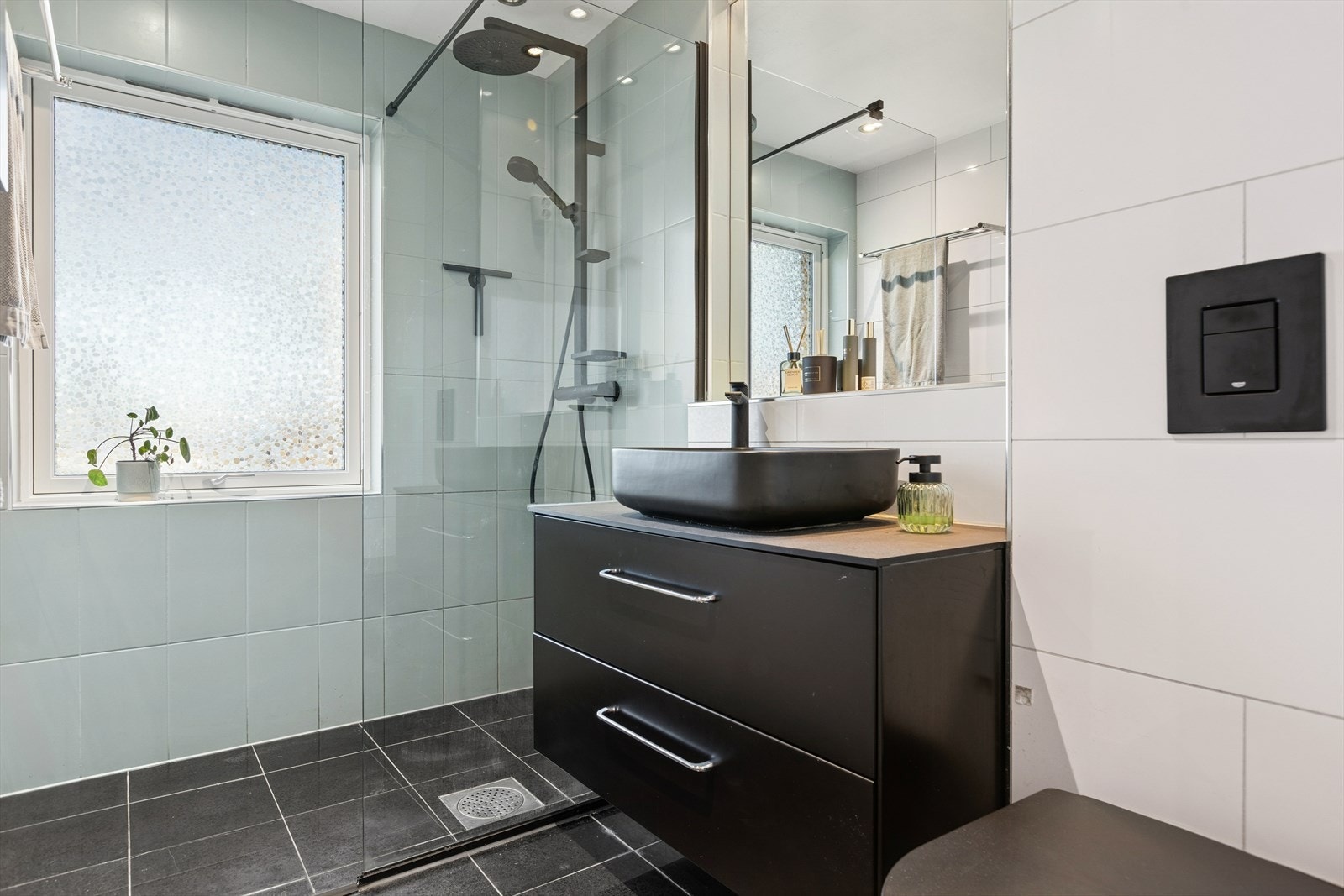 Dusjvegg av glass og vegghengt toalett gir en praktisk våtromsløsning. Galleribilde