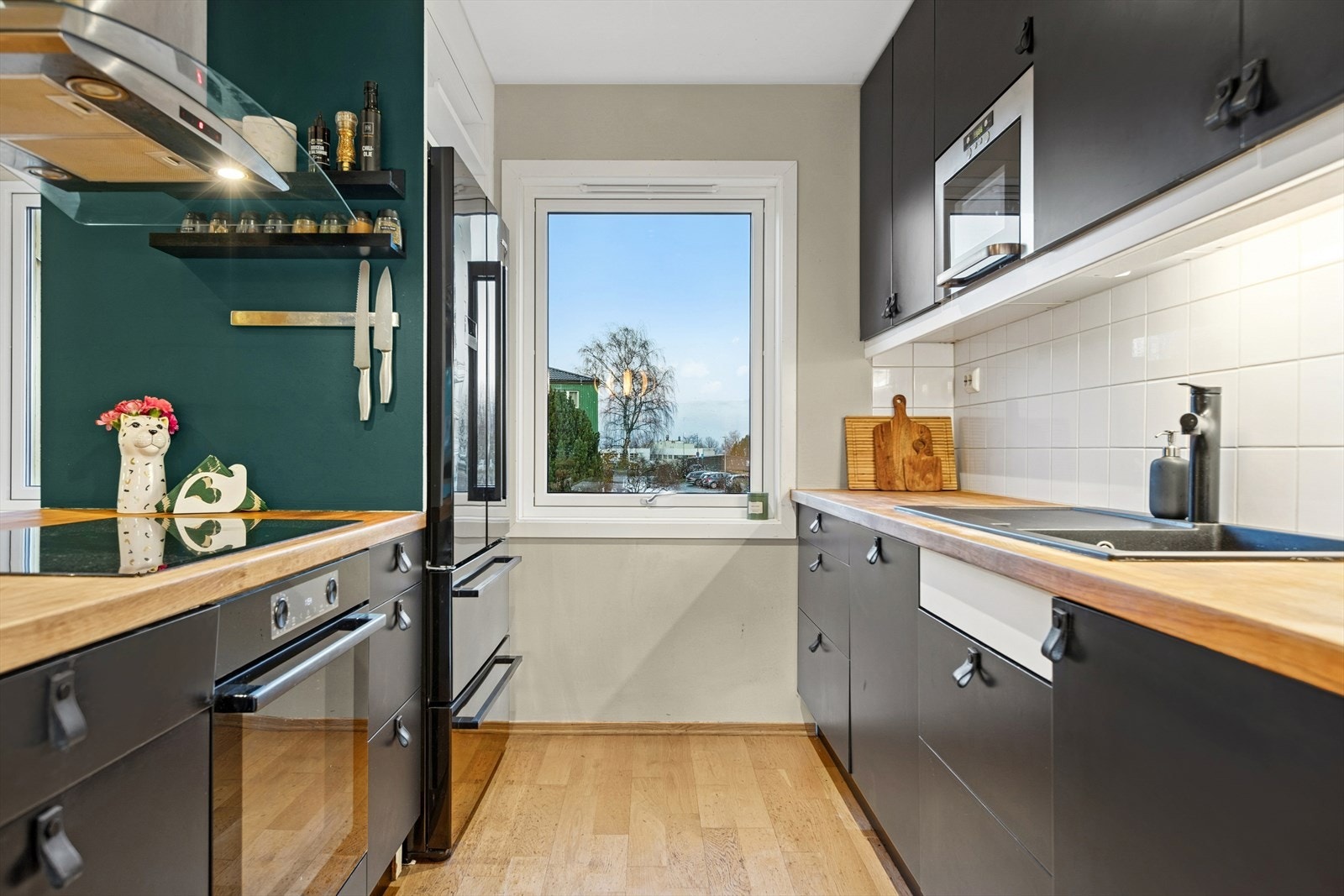 Integrerte hvitevarer, inkludert oppvaskmaskin og mikrobølgeovn, gir en effektiv kjøkkenløsning. Galleribilde