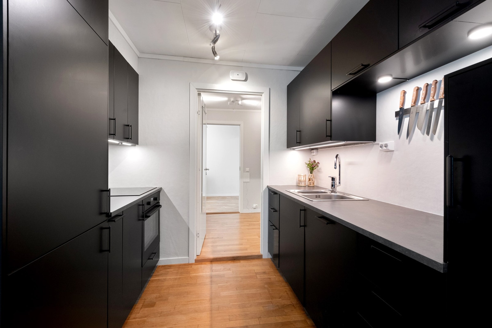 Kjøkkenet har god skapplass, integrerte hvitevarer og laminat benkeplate Galleribilde