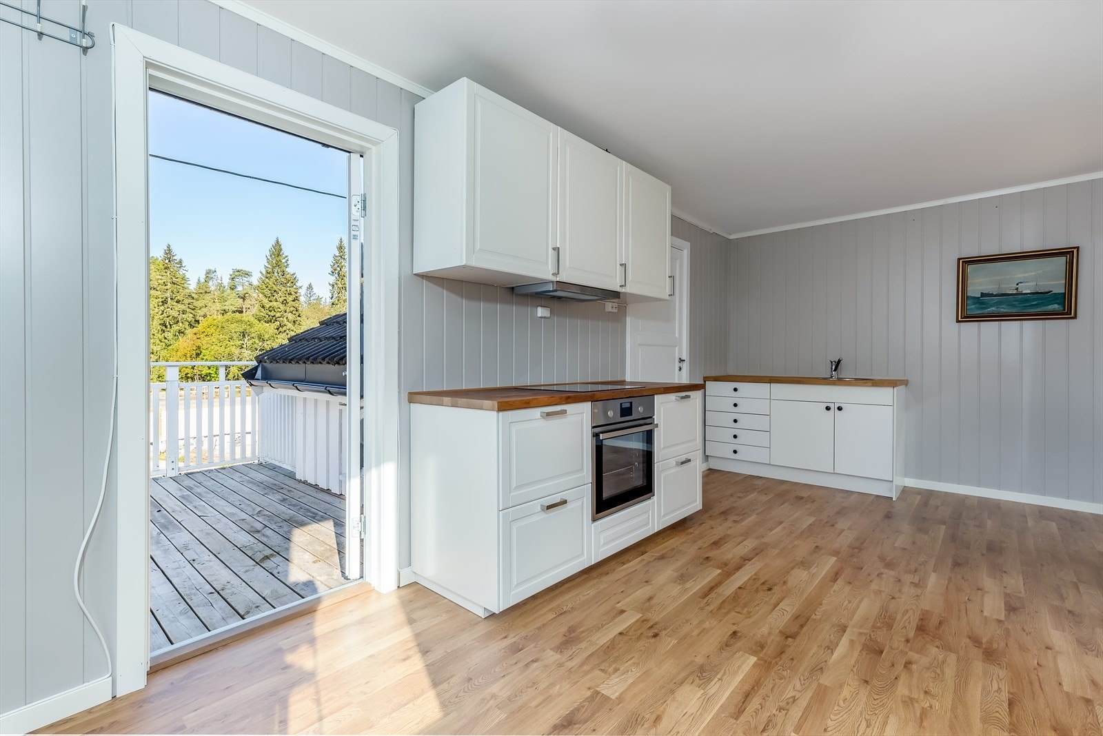 Romslig kjøkken med mye skap- og benkeplass Galleribilde